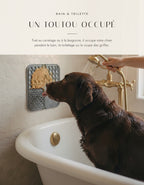 Labrador occupé par le tapis de léchage fixé au carrelage pendant le bain